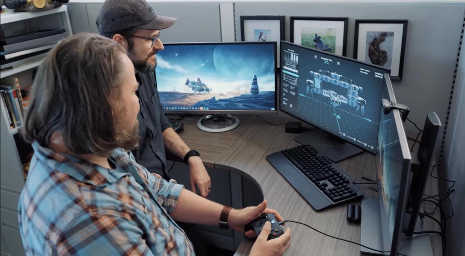 Two Bethesda workers sit at a pc designing ships